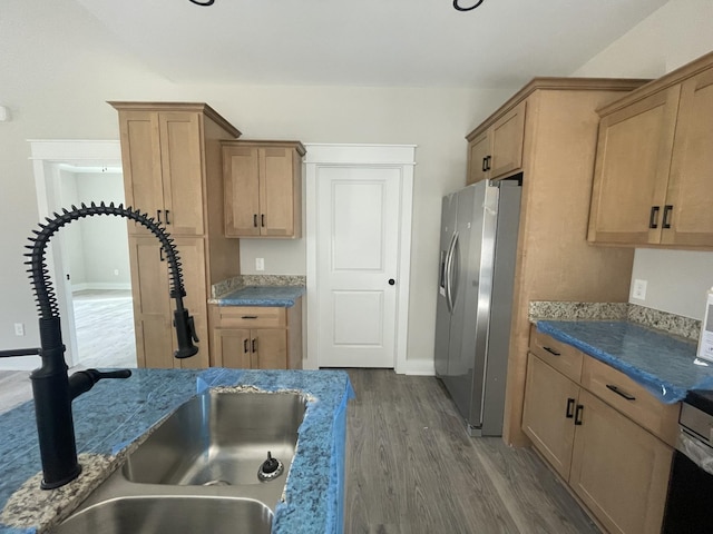 kitchen featuring stainless steel refrigerator with ice dispenser, dark hardwood / wood-style flooring, stone countertops, and sink