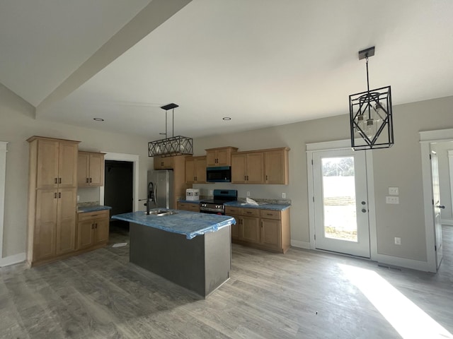 kitchen with pendant lighting, a center island with sink, stainless steel appliances, and light hardwood / wood-style flooring