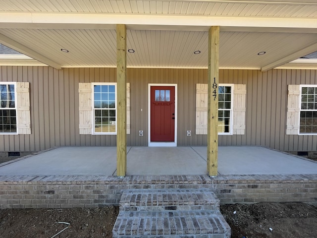 doorway to property with a porch and crawl space