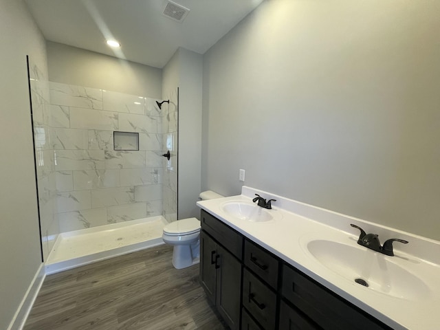 bathroom with toilet, wood finished floors, a sink, and visible vents