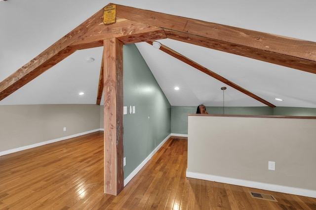 bonus room with hardwood / wood-style flooring and vaulted ceiling with beams