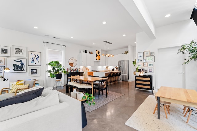 living room featuring a chandelier and sink