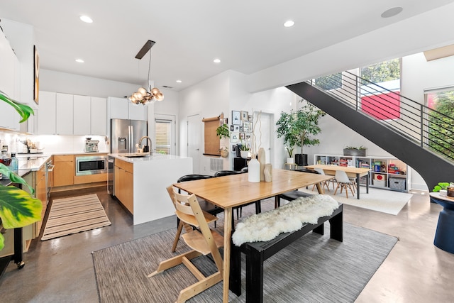 dining area with sink and a notable chandelier