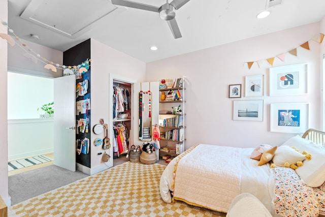 bedroom with ceiling fan, light colored carpet, and a closet