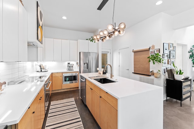 kitchen with appliances with stainless steel finishes, a center island with sink, white cabinets, and sink