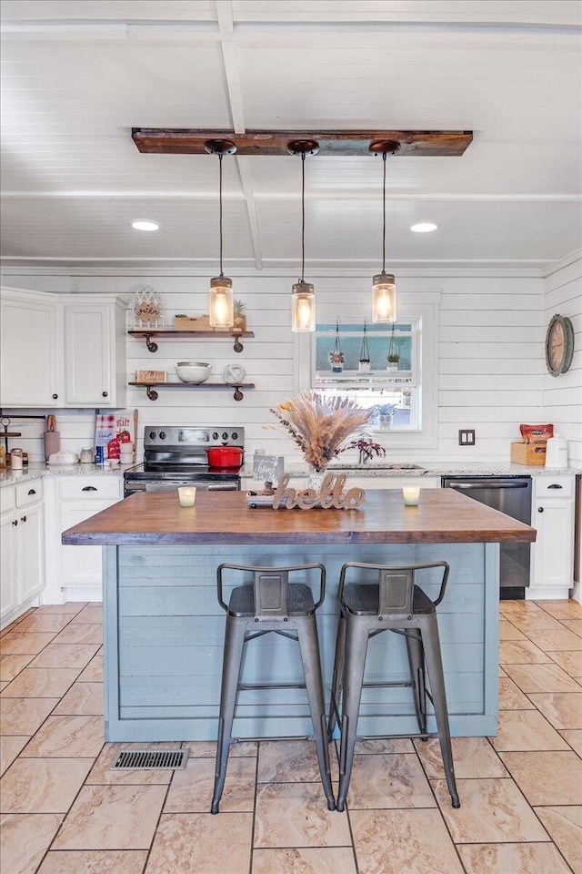 kitchen with white cabinets, pendant lighting, a kitchen bar, and a center island