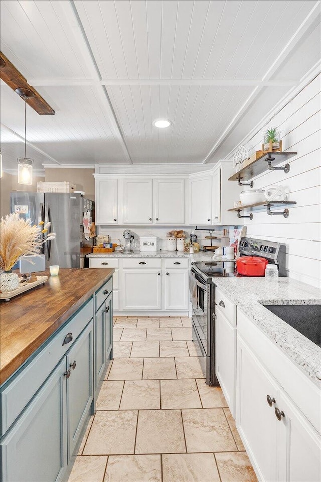 kitchen with butcher block countertops, pendant lighting, white cabinetry, and appliances with stainless steel finishes