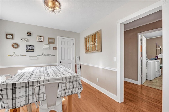 bedroom featuring wood-type flooring and separate washer and dryer