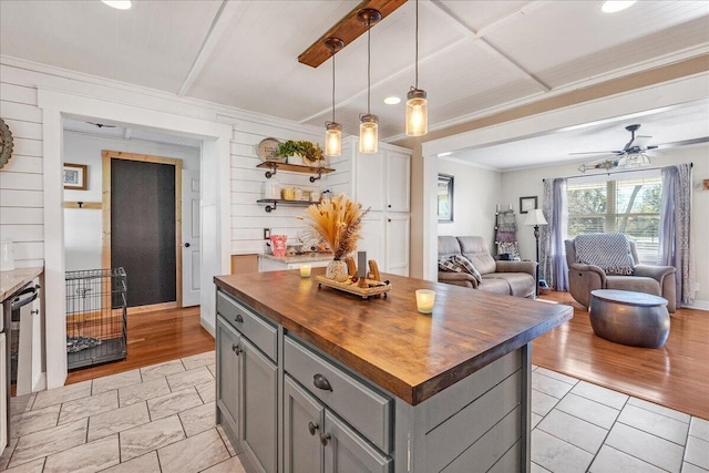 kitchen with wood counters, gray cabinetry, a center island, light hardwood / wood-style floors, and hanging light fixtures