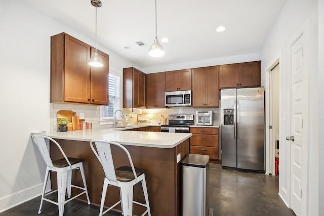 kitchen with stainless steel appliances, tasteful backsplash, sink, hanging light fixtures, and kitchen peninsula