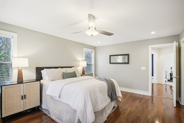 bedroom with ceiling fan, dark hardwood / wood-style flooring, and multiple windows