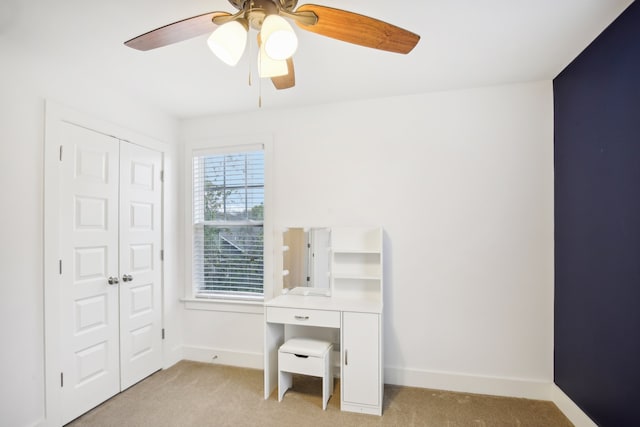 carpeted office space featuring ceiling fan