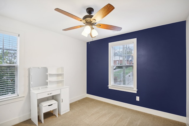 unfurnished office with ceiling fan and light carpet