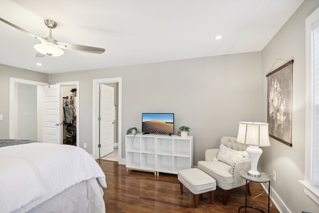 bedroom with a closet, ceiling fan, dark hardwood / wood-style flooring, a walk in closet, and connected bathroom