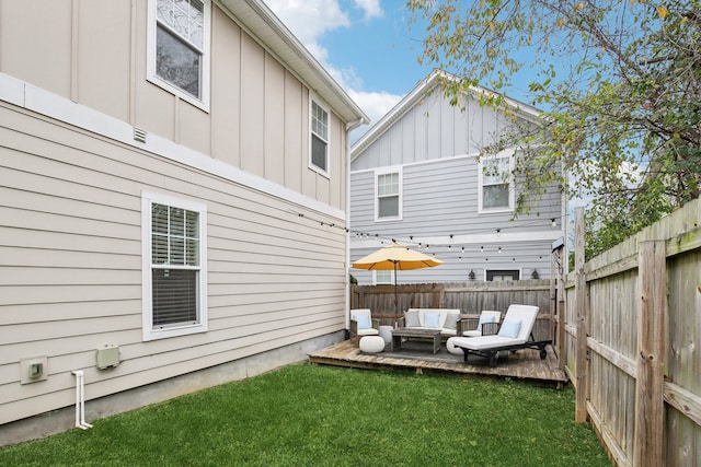 back of house featuring a wooden deck, a yard, and outdoor lounge area