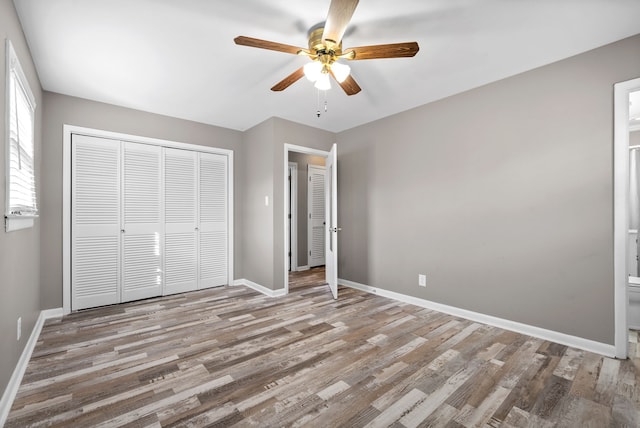 unfurnished bedroom featuring ceiling fan, light wood-type flooring, and a closet