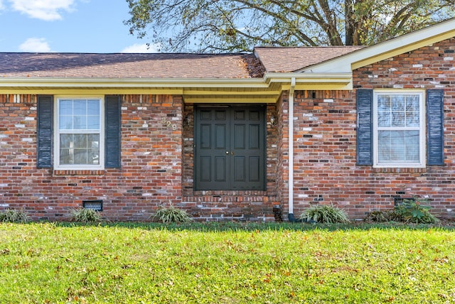 entrance to property with a lawn