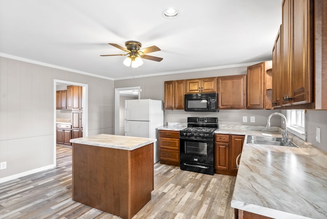 kitchen with sink, crown molding, light hardwood / wood-style floors, a kitchen island, and black appliances