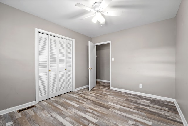 unfurnished bedroom with ceiling fan, light hardwood / wood-style floors, and a closet