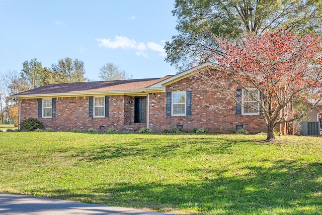 ranch-style house featuring cooling unit and a front lawn