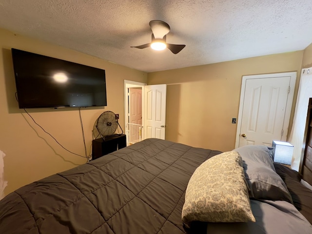 bedroom with ceiling fan and a textured ceiling