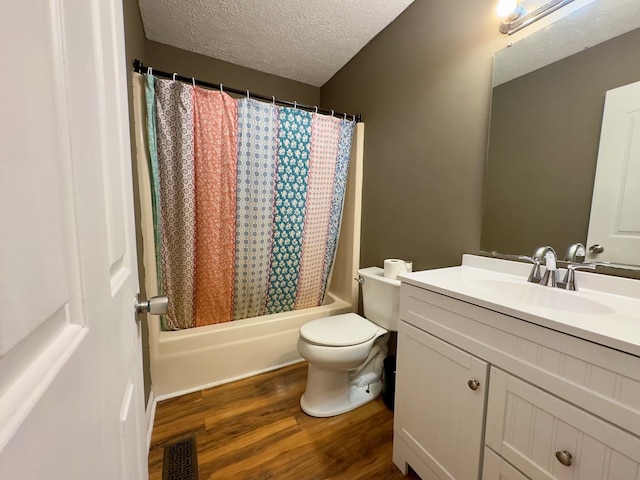 full bathroom with shower / tub combo, vanity, a textured ceiling, wood-type flooring, and toilet