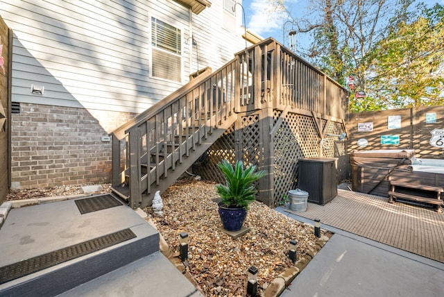 view of home's exterior featuring a hot tub, cooling unit, and a deck