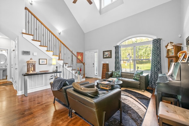 living room with hardwood / wood-style flooring, high vaulted ceiling, and ceiling fan