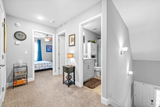 hallway featuring light colored carpet and lofted ceiling