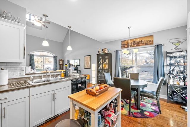 kitchen featuring sink, tasteful backsplash, light hardwood / wood-style flooring, pendant lighting, and white cabinets