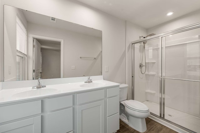 bathroom with wood-type flooring, vanity, toilet, and an enclosed shower