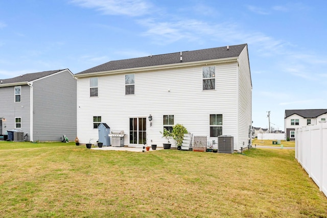 rear view of property featuring a yard, central AC, and a patio area