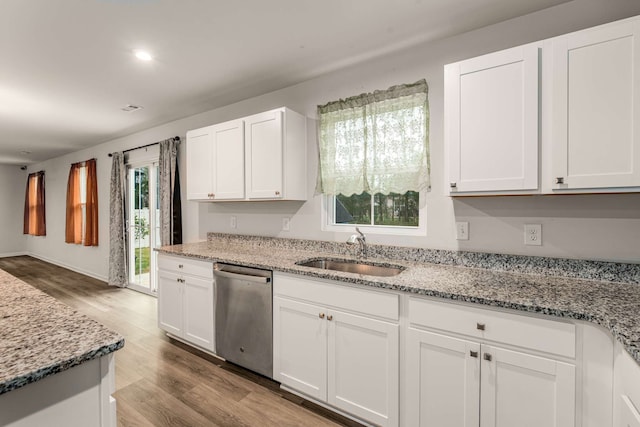 kitchen with dishwasher, sink, light hardwood / wood-style flooring, light stone counters, and white cabinetry