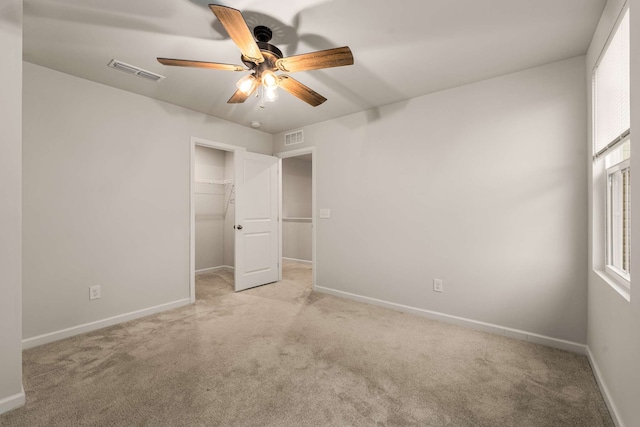 unfurnished bedroom featuring light carpet, a closet, and ceiling fan