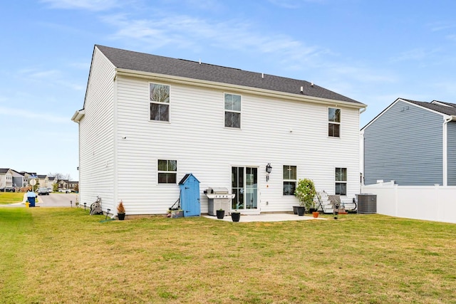 rear view of house with a patio area, a yard, and central AC unit