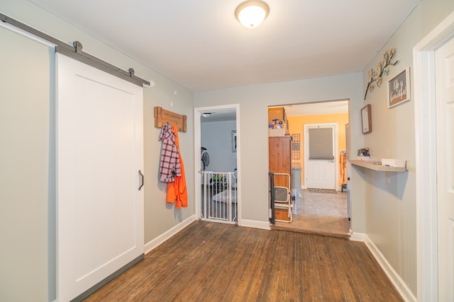 corridor featuring dark hardwood / wood-style flooring and a barn door