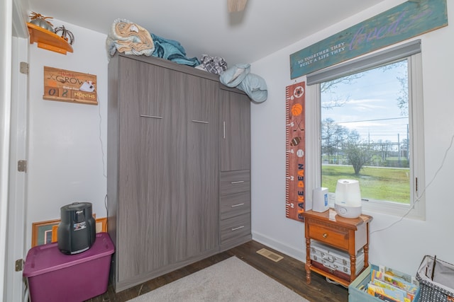 misc room with ceiling fan, dark wood-type flooring, and a wealth of natural light