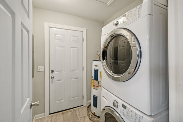 clothes washing area with light wood-type flooring, electric water heater, and stacked washer and clothes dryer