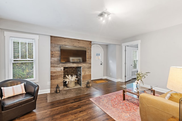 living room featuring dark hardwood / wood-style floors and a large fireplace