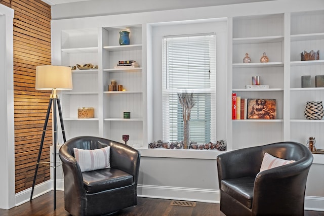 living area featuring dark hardwood / wood-style flooring and built in features