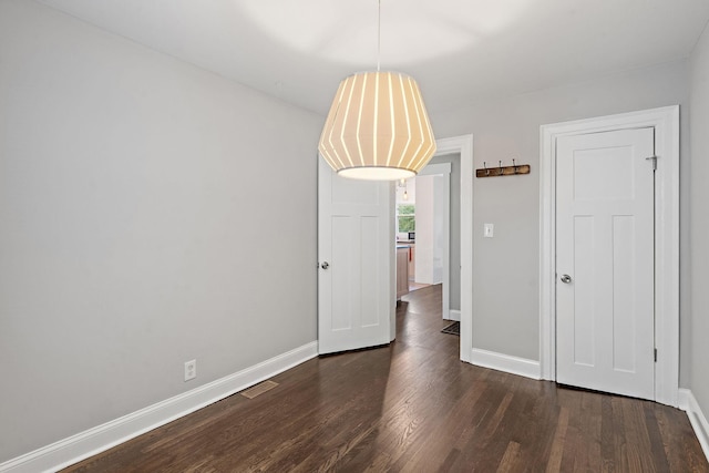 unfurnished room with dark wood-type flooring