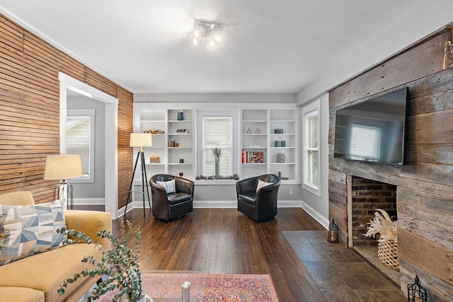 living room featuring built in shelves and dark wood-type flooring