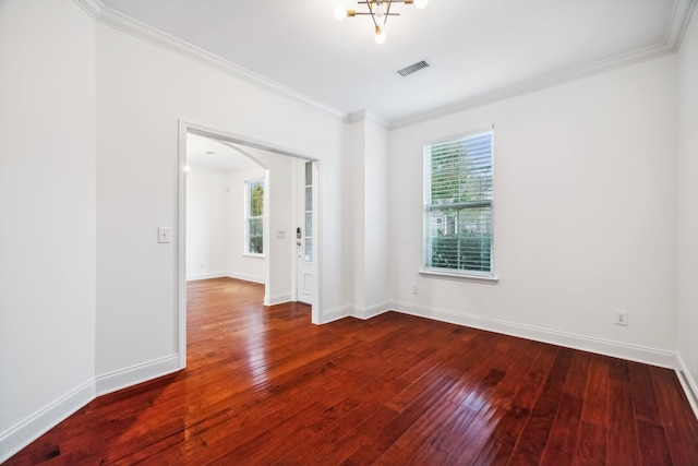 empty room with hardwood / wood-style flooring, an inviting chandelier, and crown molding