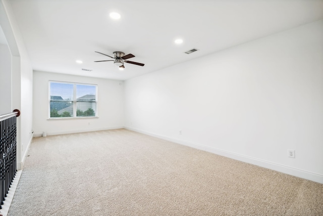 carpeted spare room featuring ceiling fan