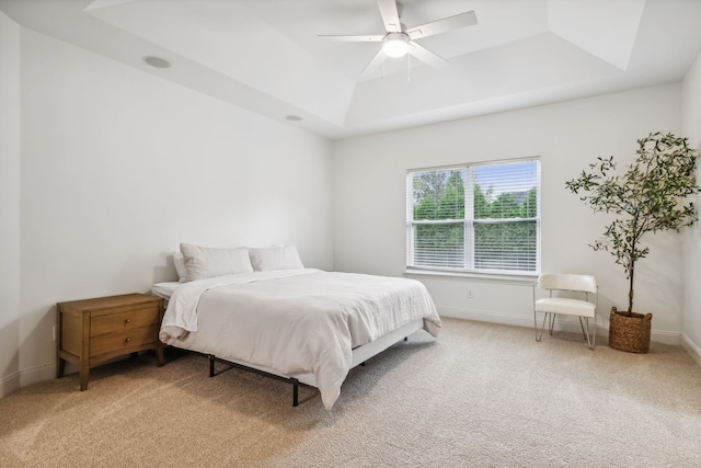 bedroom with carpet, ceiling fan, and a raised ceiling