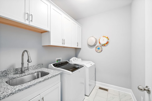 laundry area with cabinets, independent washer and dryer, and sink