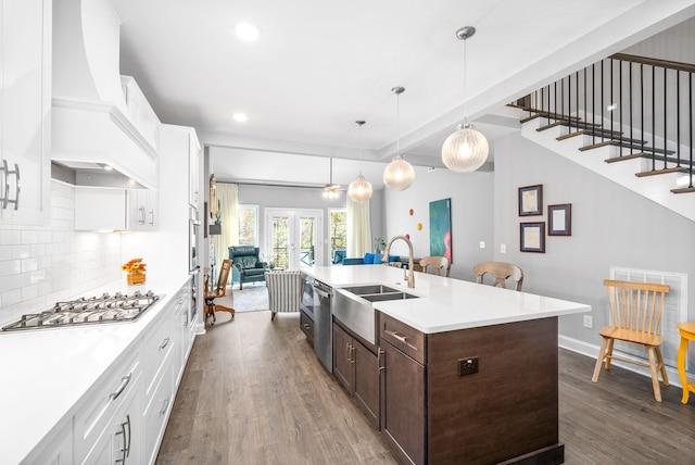 kitchen with pendant lighting, sink, dark hardwood / wood-style flooring, white cabinetry, and stainless steel appliances