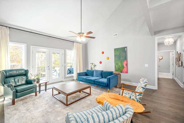 living room with hardwood / wood-style flooring, ceiling fan with notable chandelier, high vaulted ceiling, and french doors