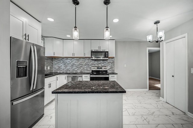 kitchen with pendant lighting, white cabinets, stainless steel appliances, and a kitchen island