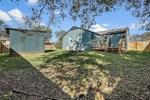 rear view of house with a lawn and a wooden deck